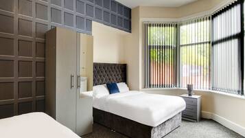 Desk, iron/ironing board, bed sheets