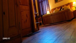 Un interior de madera con una puerta grande, un banco y un cuadro en la pared.