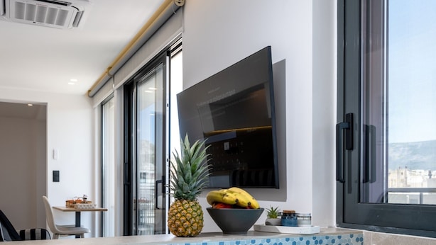 A modern indoor pool with clear blue water, a pineapple, and a bowl of fruit on the edge. - Heart of Athens Apartments (Athens)