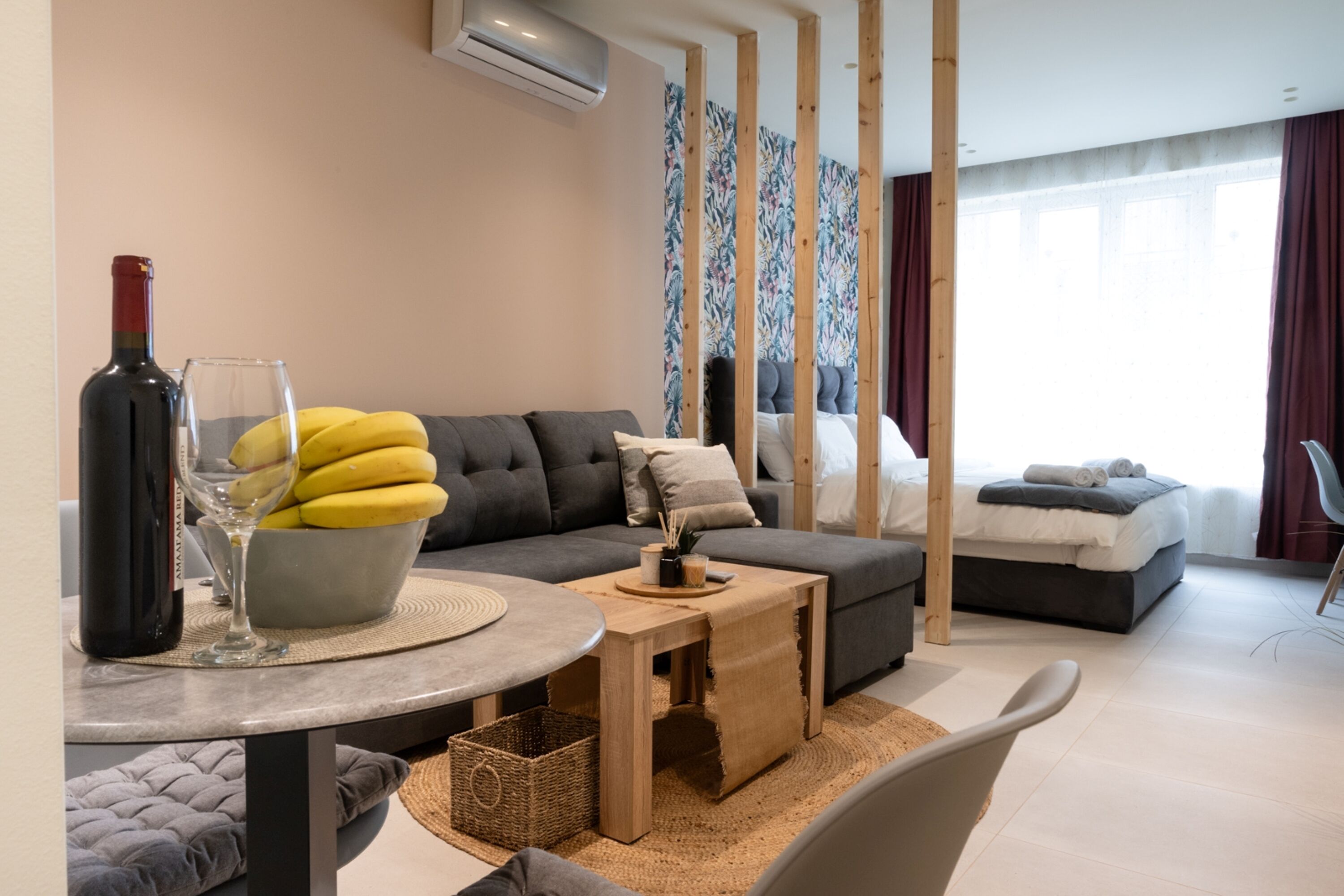 Uma sala moderna com sofá, mesa de centro, mesa de jantar e cama.