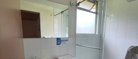 Un baño moderno con inodoro, lavamanos y ducha.