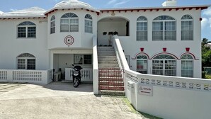 Um edifício branco com várias janelas e uma escadaria que leva à entrada.