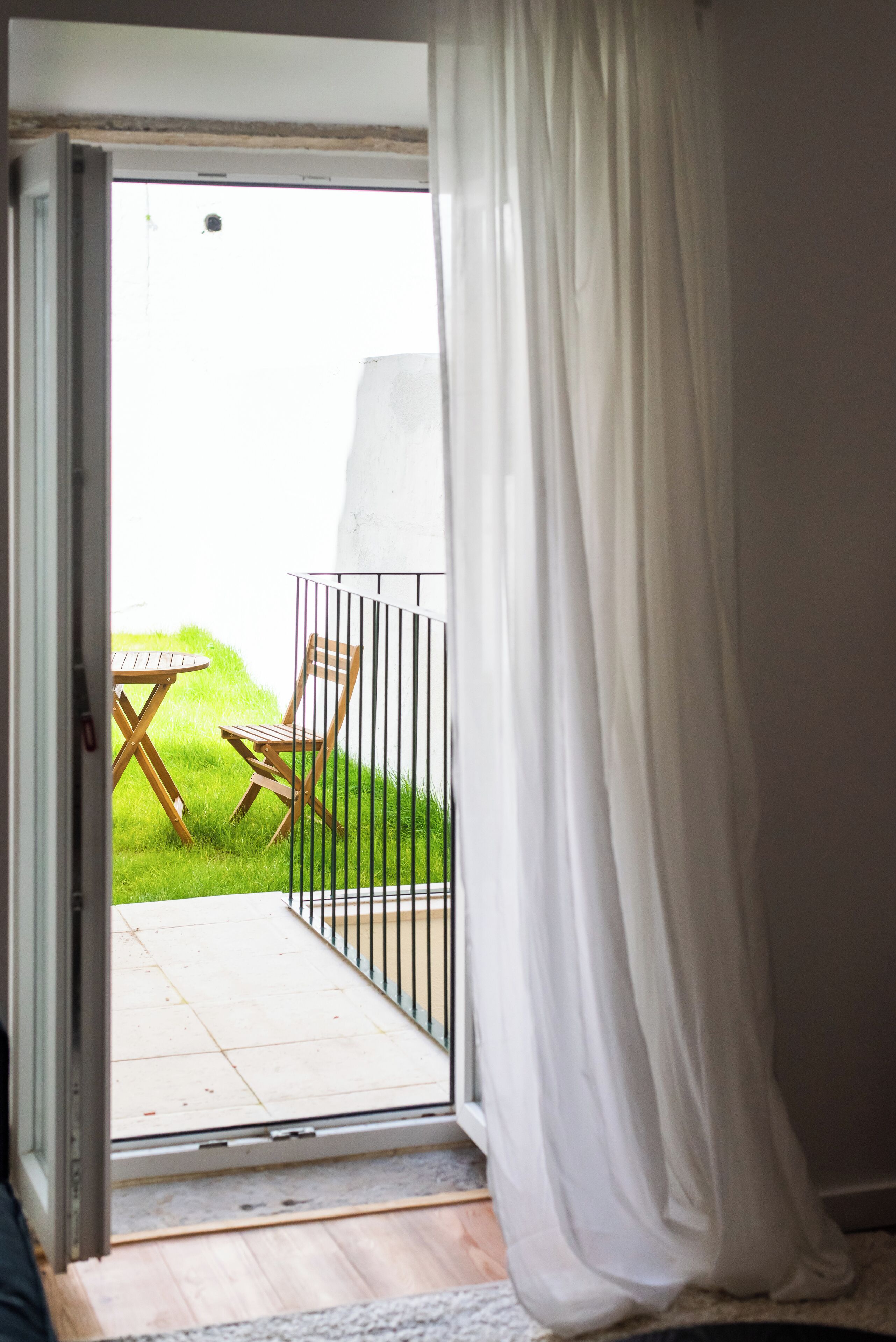 A room with a sliding glass door leading to a patio with a table and chairs.