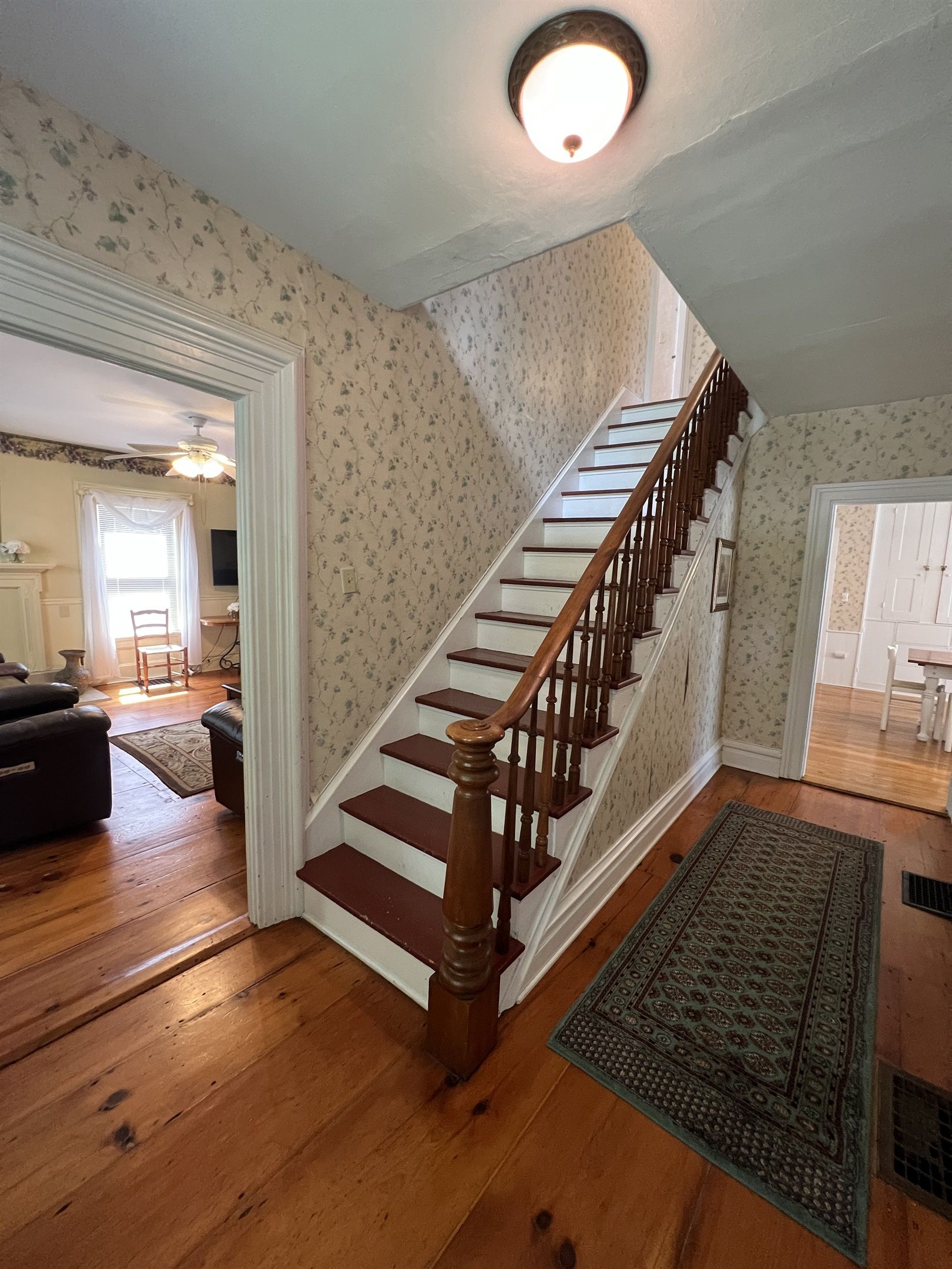 Un escalier avec des marches en bois et une rampe, menant à l’étage supérieur.