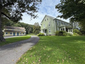 A two-story house with a porch, a driveway, and a lawn.