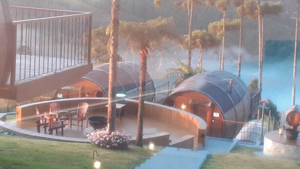 A modern resort with dome-shaped cabins, a deck with seating, and a pool area. - Pousada Villa Barril (Camanducaia)