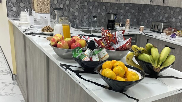 Una isla de cocina con encimera de mármol, rodeada de armarios y un salpicadero hexagonal.