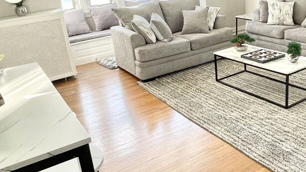 A spacious living room with a high ceiling, large windows, and a cozy seating area. - Harrisburg apt Great River View (Harrisburg)