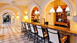 Eine Bar mit Schachbrettmuster-Boden, Barhocker und einer gewölbten Decke.