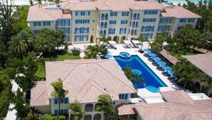 Ein großes Resort mit mehreren Gebäuden, einem zentralen Swimmingpool und Blick auf den Strand.