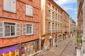 A narrow street with buildings featuring traditional European architecture, including shuttered windows and brick facades. - Roma Maximus - en plein coeur historique vieille ville (Toulouse)