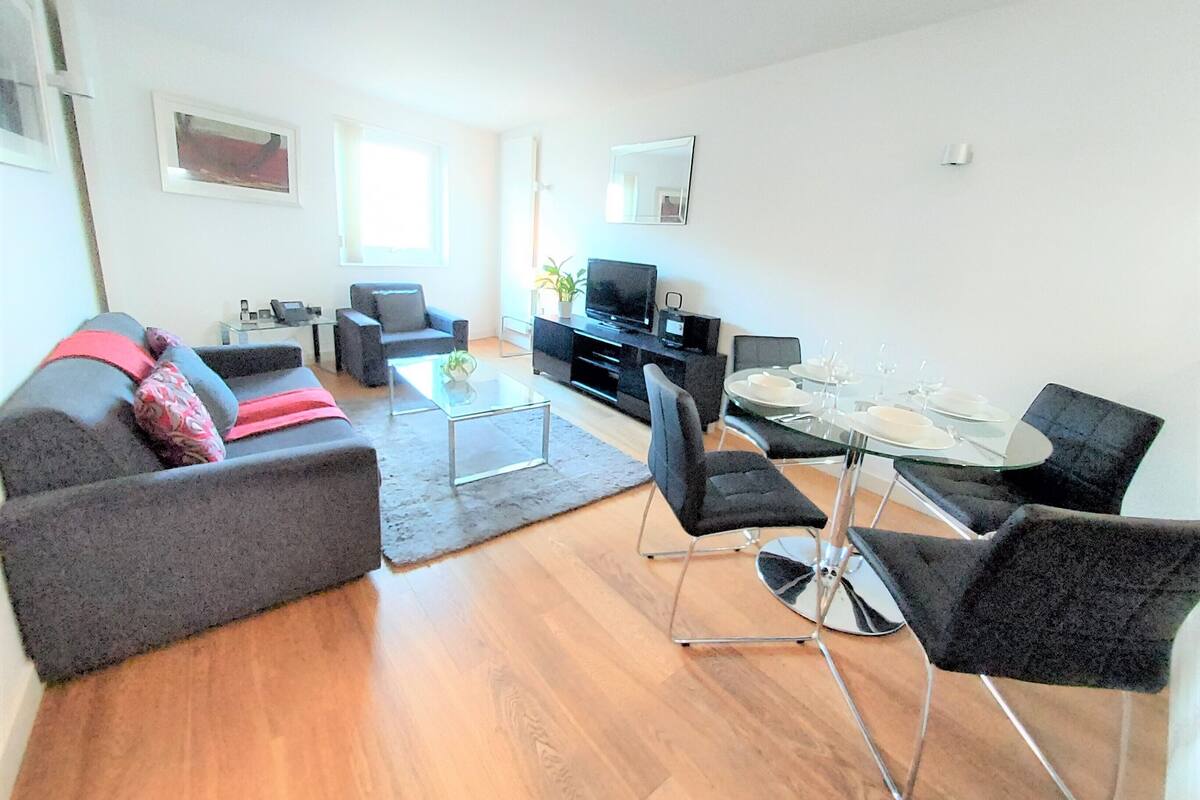 A modern living room with a sofa, coffee table, and dining area.