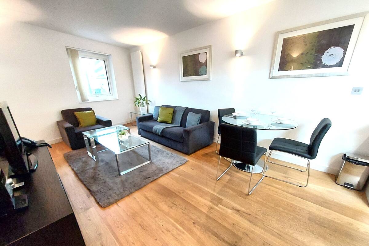 A modern living room with a sofa, coffee table, and dining area.