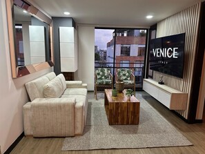 Ein modernes Wohnzimmer mit einer Couch, einem Couchtisch, einem Fernseher und Blick auf Venedig.