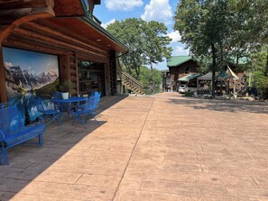 A wooden lodge with outdoor seating and a mountain view mural.