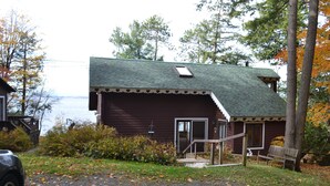 A rustic cabin with a sloped roof, a porch, and a bench. - Lake Champlain house: sunsets, mountains, fishing (Georgia)