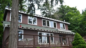 A two-story house with a deck and a covered porch. - Lake Champlain house: sunsets, mountains, fishing (Georgia)