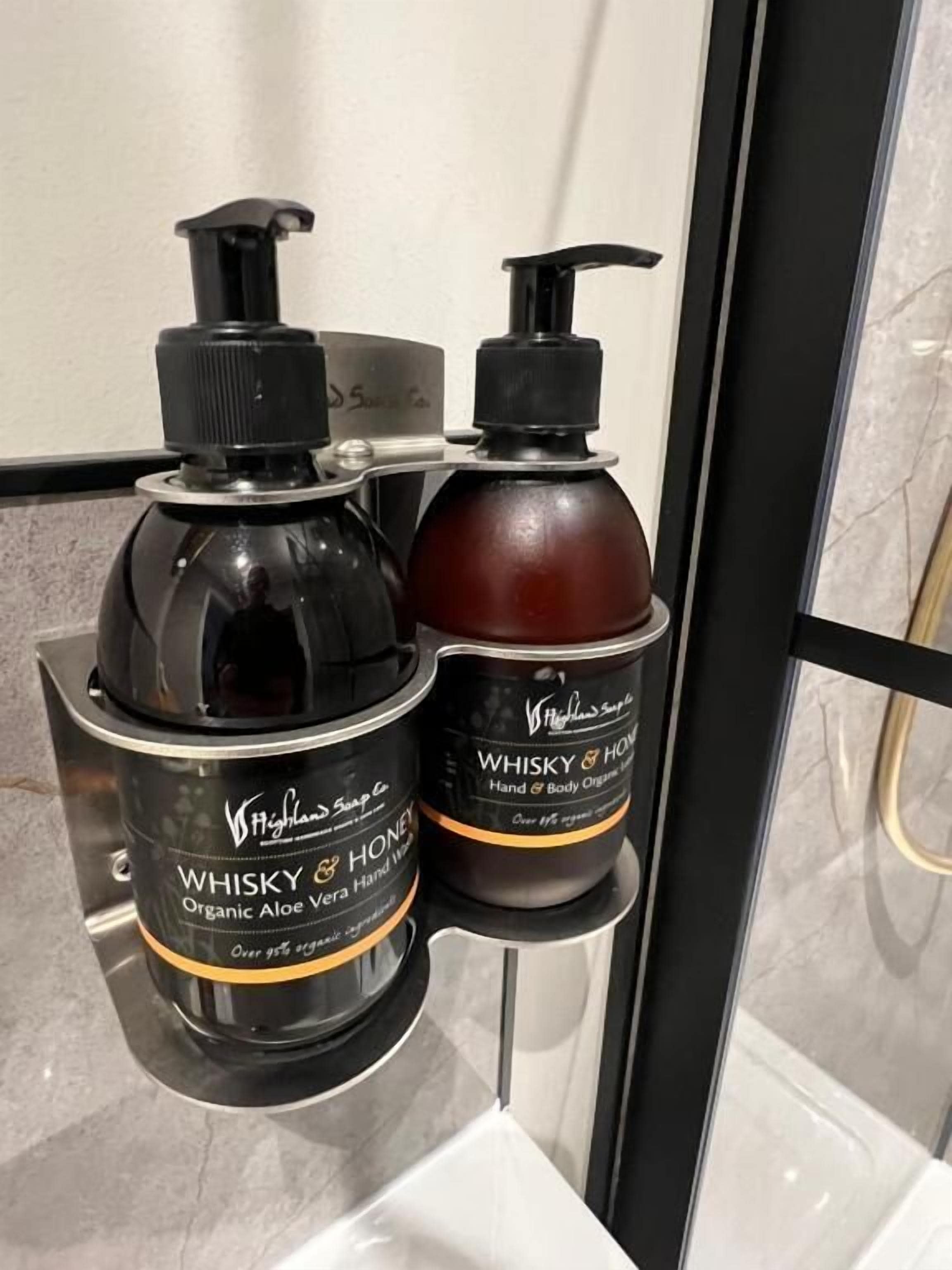 Two bottles of Whisky & Honey organic aloe vera hand wash on a bathroom counter.