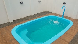 Una piscina rettangolare con rivestimento blu e un solo rubinetto.