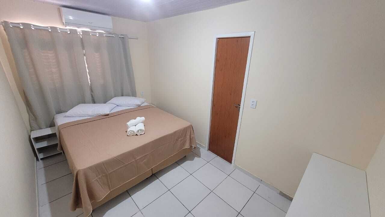 Une chambre à coucher avec un lit, une porte en bois et un rideau.