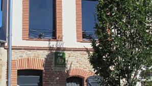 A two-story building with a brick facade, large windows, and a tiled roof. - Gîte "La Cordonnerie (MONTGAILLARD LAURAGAIS)