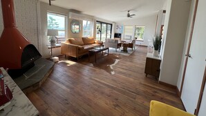 A spacious living room with a fireplace, a sofa, a coffee table, and a TV. - Stylish Lake Retreat on Blue Bay, Flathead Lake, Montana with private beach! (Polson)