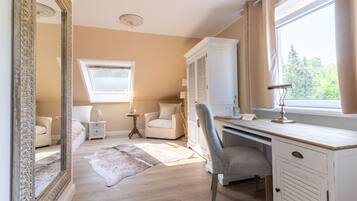 A bedroom with a large mirror, a desk, a chair, a bed, and a window with curtains.