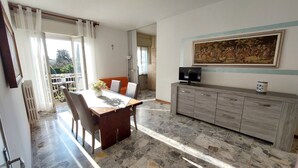 Un comedor con una mesa, sillas, un televisor y un aparador.