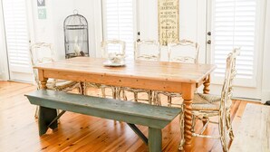 Una mesa de comedor con un banco, rodeada de sillas de estilo vintage.