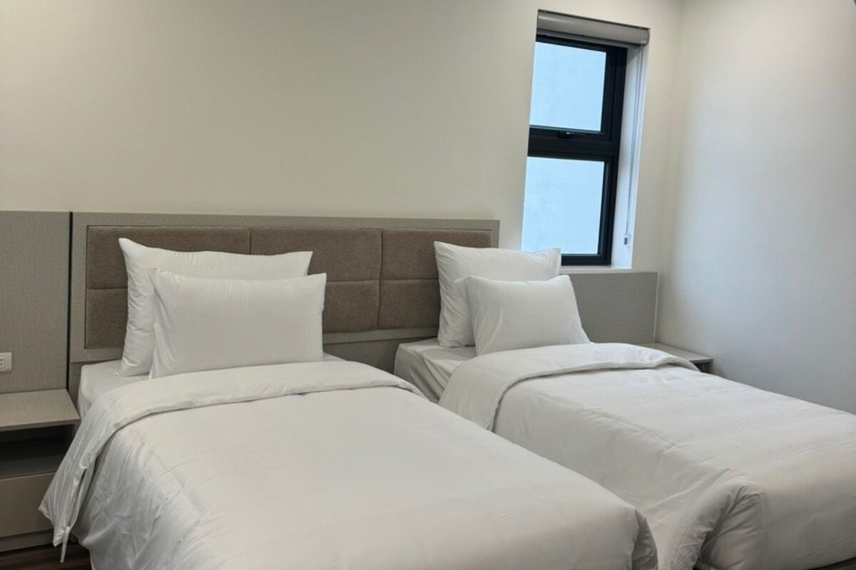 Une chambre double de luxe avec deux lits, une fenêtre et un design moderne.