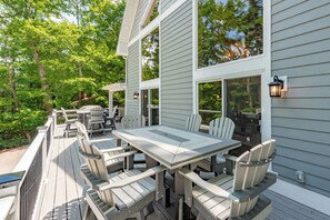 Une terrasse avec une table et des chaises, donnant sur une zone boisée.