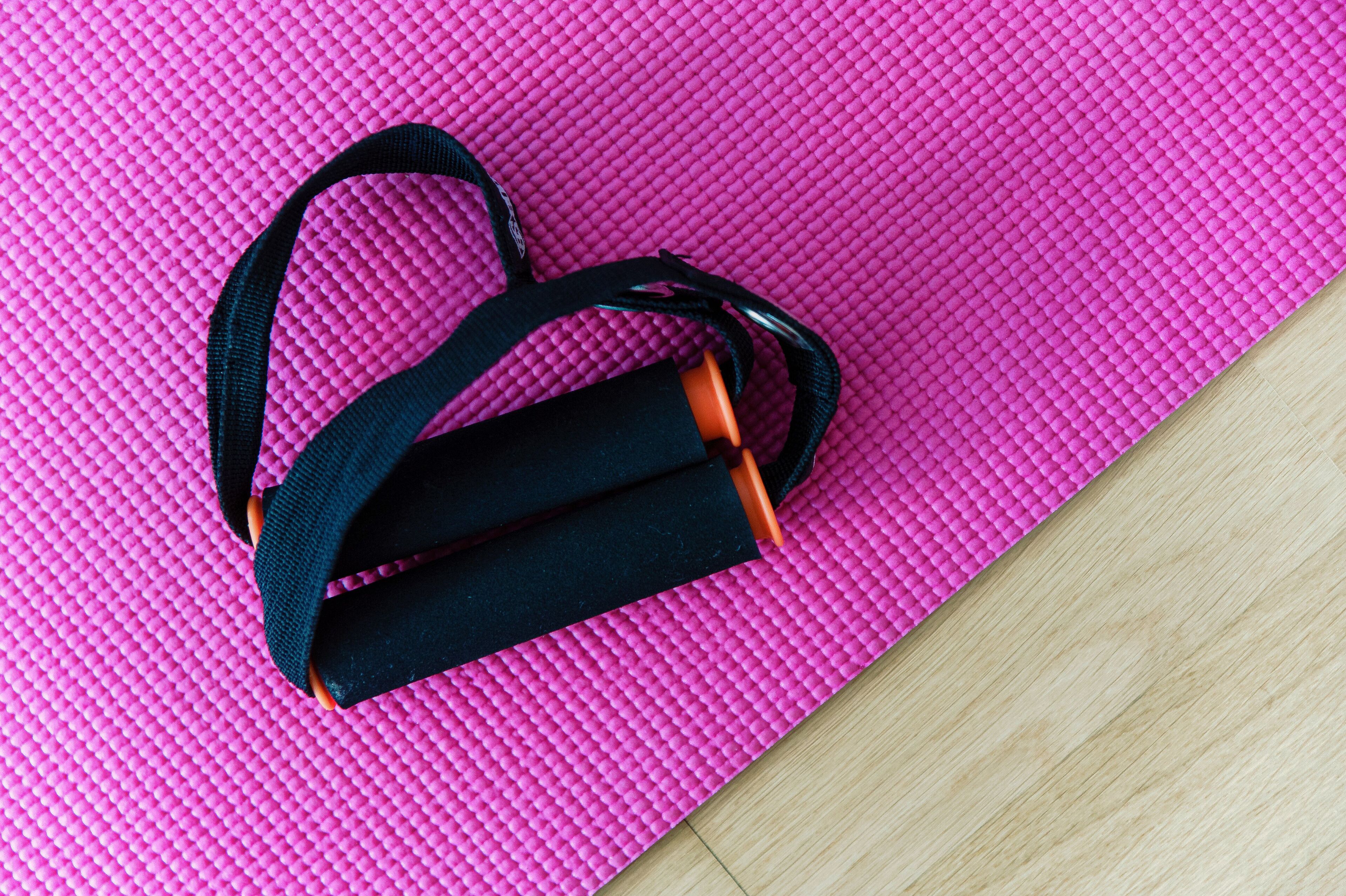 A pink textured mat with a black and orange object on it.