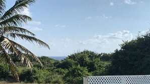 A balcony with a white plastic cup, a small table, and a sign instructing to close the gate. - Spacious Lailamar Villa with Pool & Bar, Ocean View - Ground Floor (St. Philip)