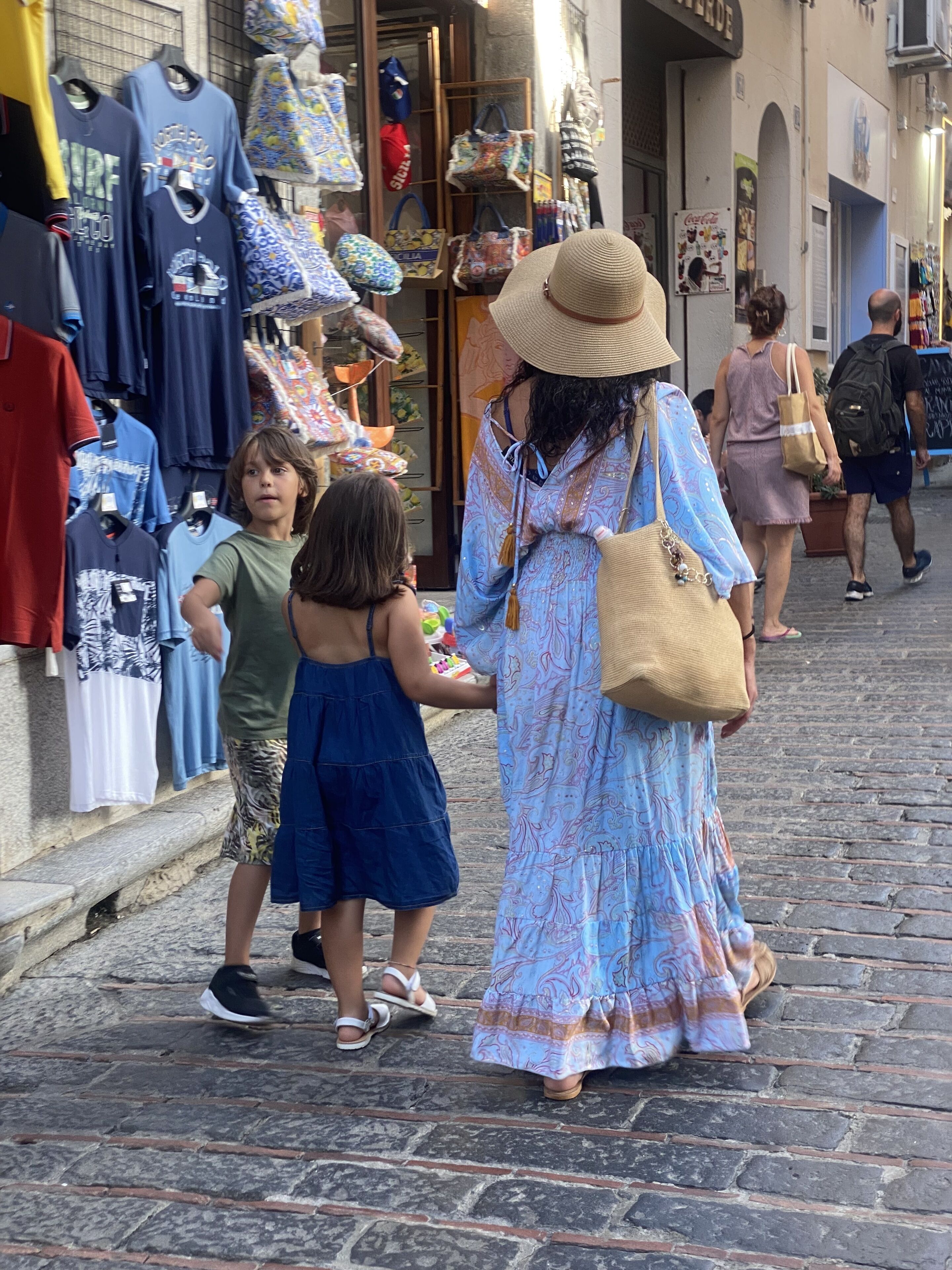 A cobblestone street with shops on either side.