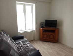 Cozy living space with a sofa and flat-screen TV, perfect for relaxation and entertainment.