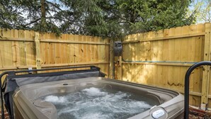 A hot tub with a wooden fence in the background.