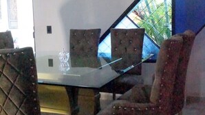 A dining area with a glass-top table and four upholstered chairs with button details. - Total Confort y Tranquilidad! Apartamento Deluxe Donde Anita (Florencia)