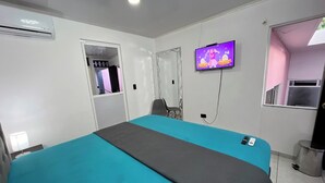 A hotel room with a bed, a TV, a window, and an air conditioning unit. - Total Confort y Tranquilidad! Apartamento Deluxe Donde Anita (Florencia)