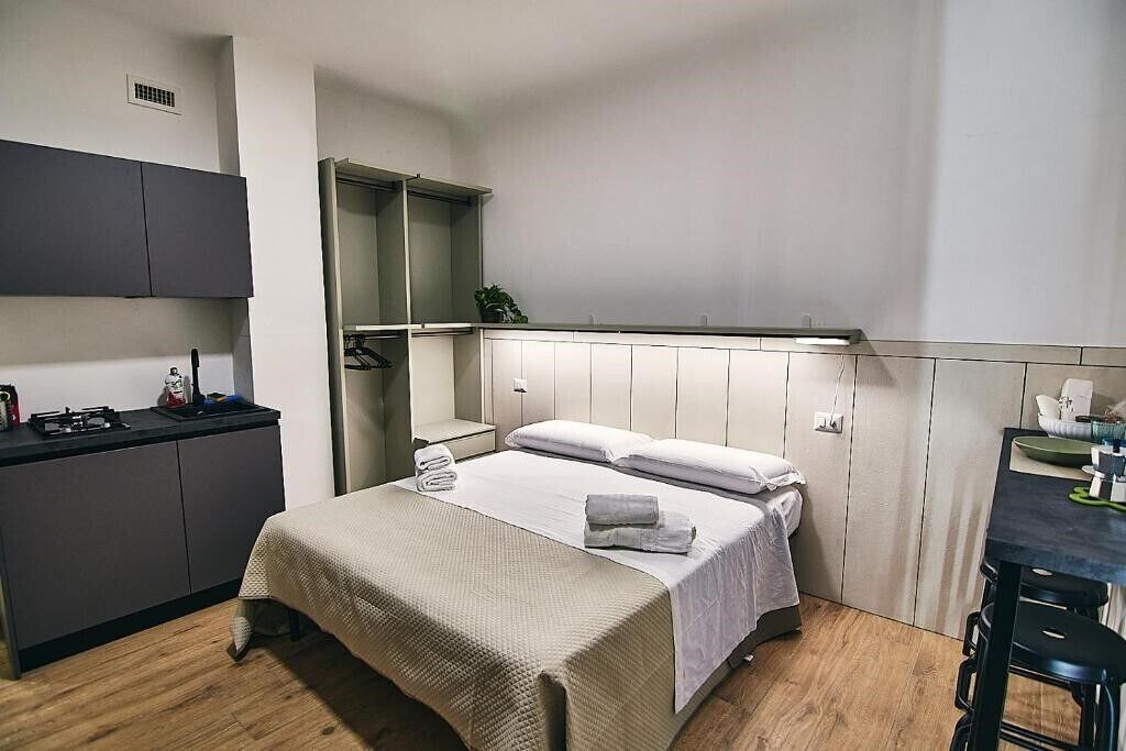 Une pièce de taille modeste comprenant un lit, une petite kitchenette et un coin repas.