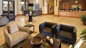 A hotel lobby with a reception desk, a concierge area, and seating arrangements. - 3BR house with hot tub in Regal Oaks Resort (Kissimmee)