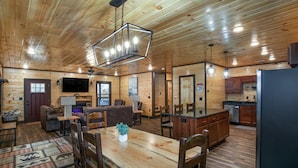 L'intérieur d'une cabane en bois comprend un coin repas, une cuisine et un salon.