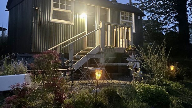A wooden cabin with a porch and steps leading to the entrance. - 1 Bedroom Cabin Sleeps 2, Private Garden, Wifi (Camelford)