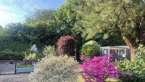 A garden with various shrubs and a statue. - 1 Bedroom Cabin Sleeps 2, Private Garden, Wifi (Camelford)