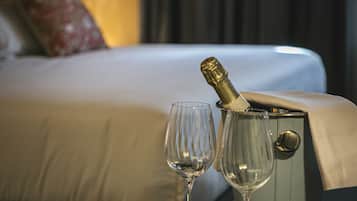 Una cama con una botella de champán y una copa.