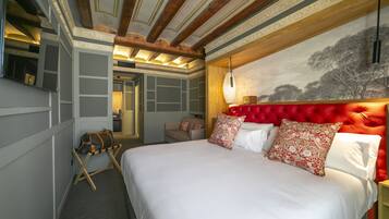 Un dormitorio con una cama grande, un cabecero tapizado rojo y una lámpara de pared.