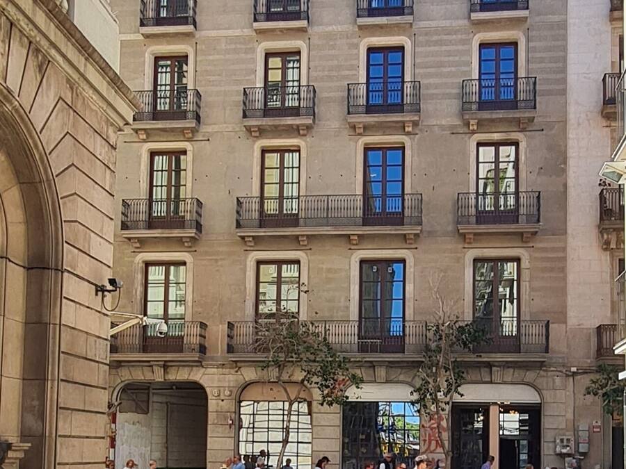 A multi-story building with a classical architectural style, featuring balconies and large windows.