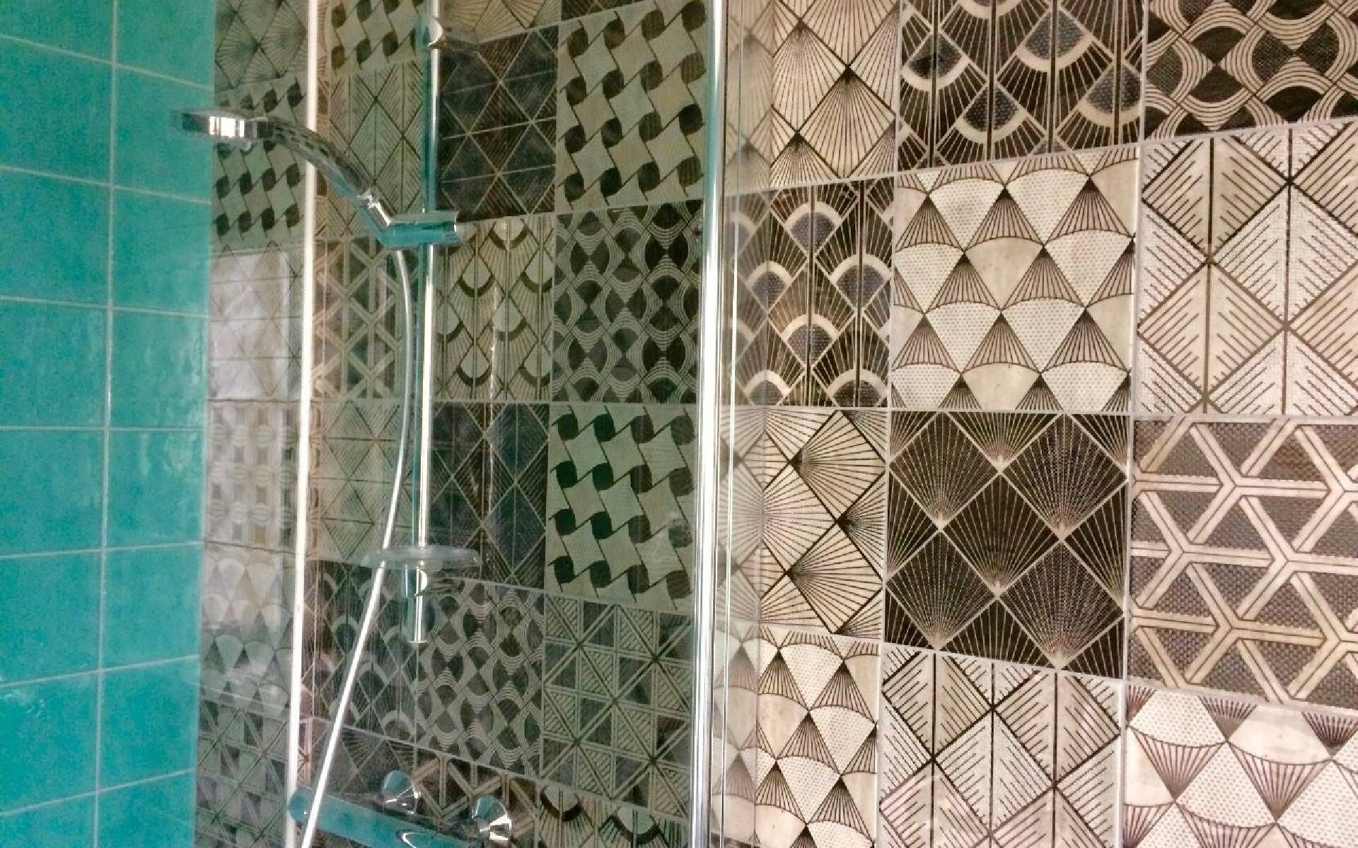Een badkamer met betegelde vloeren en een douchecabine van glas.