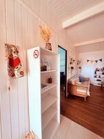 Una habitación con un armario blanco, una cama con manta escocesa y suelo de madera.