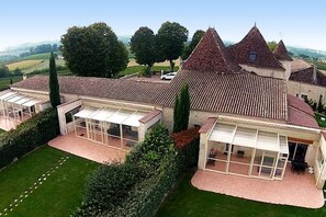 Il s’agit d’un vaste domaine comprenant plusieurs bâtiments, dont une maison principale dotée d’un toit à forte pente et plusieurs dépendances plus petites. Les jardins sont bien entretenus et offrent une vue dégagée sur le paysage environnant.