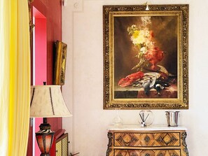 Ein Zimmer mit einem Bild eines Hummer auf einem Tisch, einer Lampe, einem Schminktisch und einem Spiegel.